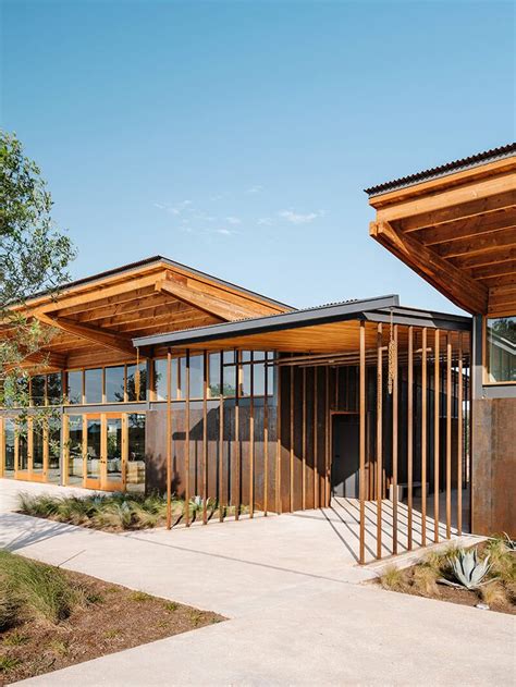 Two Wooden Buildings Sitting Next To Each Other On Top Of A Cement