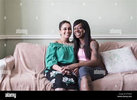 Portrait Happy Affectionate Lesbian Couple Holding Hands On Living Room Sofa Stock Photo Alamy