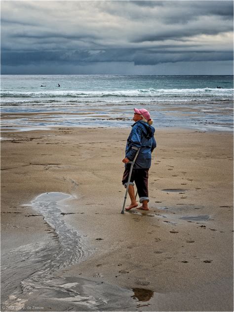 Woman With Crutches Walks On Beach Porthtowan England Luc V De