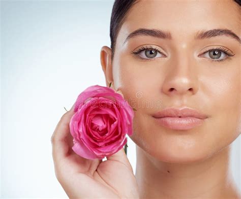 Closeup Portrait Of Beautiful Woman Holding Pink Rose While Posing