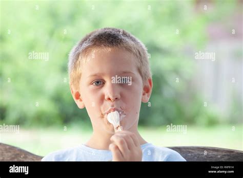 Blonde Boy Eats Ice Cream In A Messy Way Having Ice Cream All Over His Face Stock Photo Alamy