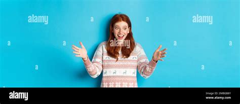 Image Of Happy Redhead Girl Holding Big Size Object Looking Amazed And Smiling Receiving