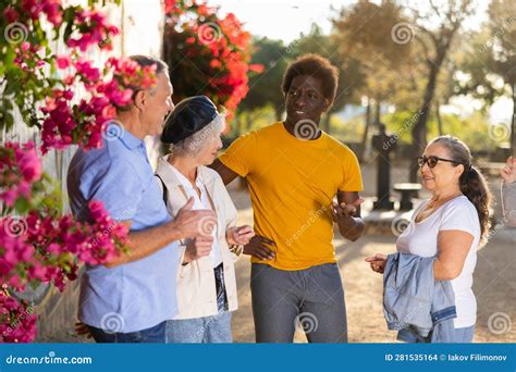 Portrait Of Mature Positive Males And Females Talking Outdoors Stock