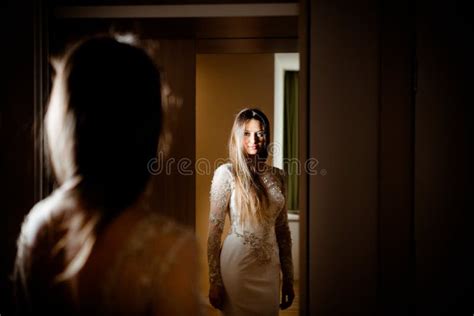 Gorgeous Brunette Woman With Long Hair And Blue Eyes Looking Herself In The Mirror Stock Photo