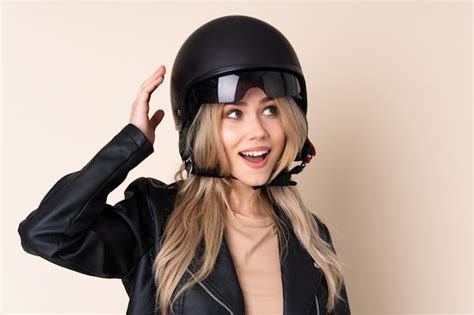 Premium Photo | Girl with a motorcycle helmet on beige wall