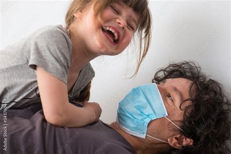 Caucasian father wearing face mask to avoid contagion with laughing ...