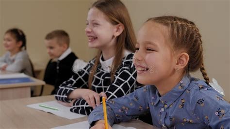 Un Grupo De Niños Sentados En Un Escritorio De Una Escuela Primaria Y