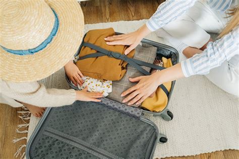 Women Packing Clothes in a Suitcase · Free Stock Photo