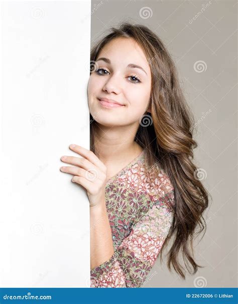 Jeune Fille De Sourire De Brunette Avec Le Signe Blanc Blanc Photo