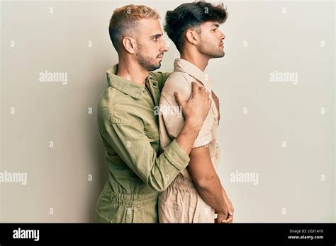 Homosexual Gay Couple Standing Together Wearing Casual Jumpsuit Looking To Side Relax Profile