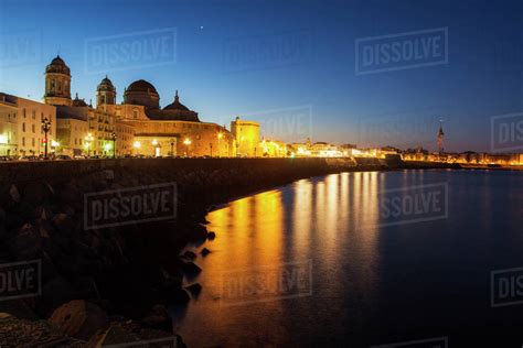 Spain, Andalusia, Cadiz, Cathedral de Cadiz and waterfront buildings at night - Stock Photo ...