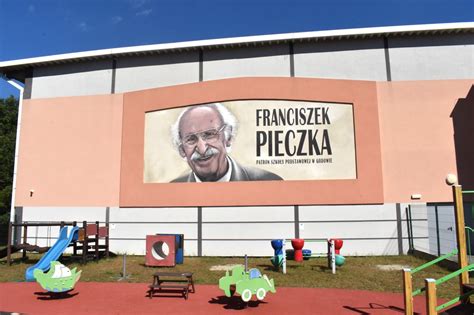 Franciszek Pieczka patrzy i się uśmiecha To mural na ścianie szkoły w