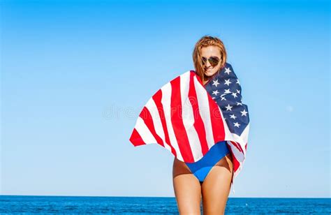 Beautiful Cheerful Woman Holding An American Flag On The Beach Stock