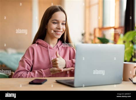 Distant education. Friendly teen girl having online lesson via laptop