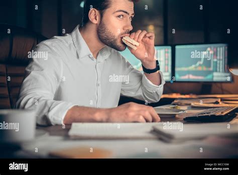 Busy Businessman Having Late Lunch Eating Sandwich In Office Working At