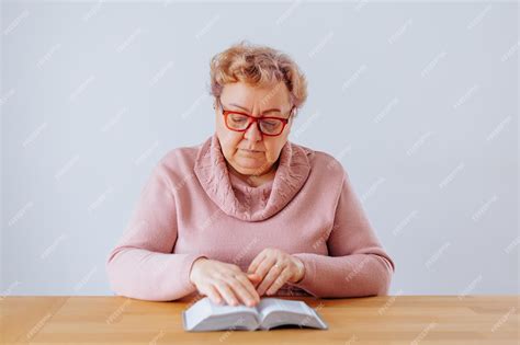 Premium Photo An Elderly Woman Sitting In Her Home Deeply Engrossed In Her Book While Wearing