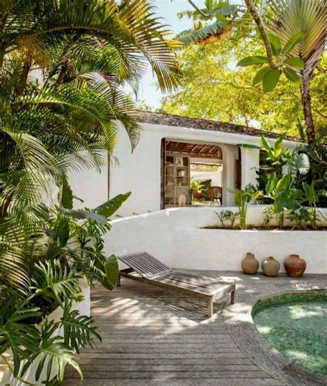 A White House Surrounded By Trees And Plants