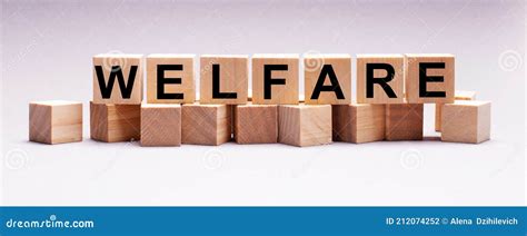 On A Light Background Wooden Cubes With The Text Welfare Stock Photo