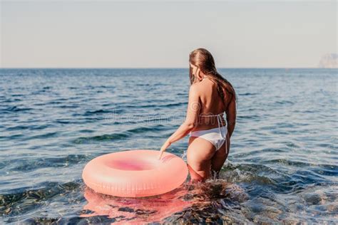 A Woman In A Bikini Is Holding A Pink Inflatable Ring In The Ocean Stock Photo Image Of Model
