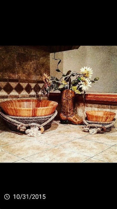 Two Bowls With Flowers In Them Sitting On A Tile Floor Next To A Vase