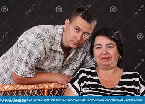 Smiling Boy Teenager Looking At The Camera Hugging An Elderly Mature Grandmother Of The S