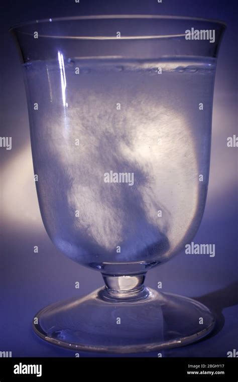 Two Effervescent Tablets Dropped Into A Glass Full Of Water Against A