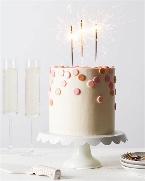 A Birthday Cake With Sparklers On Top And Two Glasses Of Champagne In