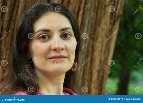 Portrait Of A 35 Year Old Brunette Woman Looking At The Camera Smiling In Nature Stock Image