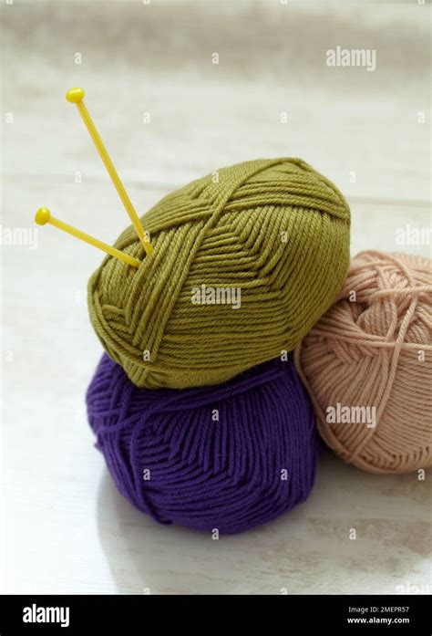 Three Balls Of Wool With Knitting Needles Stuck In One Stock Photo Alamy