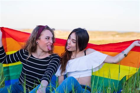 Premium Photo Two Lesbian Girls Lying On The Grass With The Gay Pride Flag