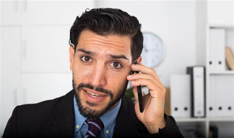 Surprised Spanish Businessman Is Talking Phone With His Partner Stock