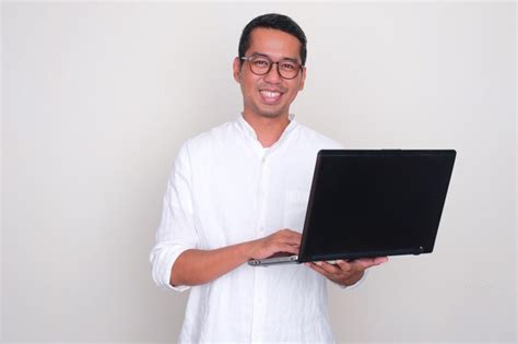 Premium Photo Adult Asian Man Smiling Confident While Holding A Laptop