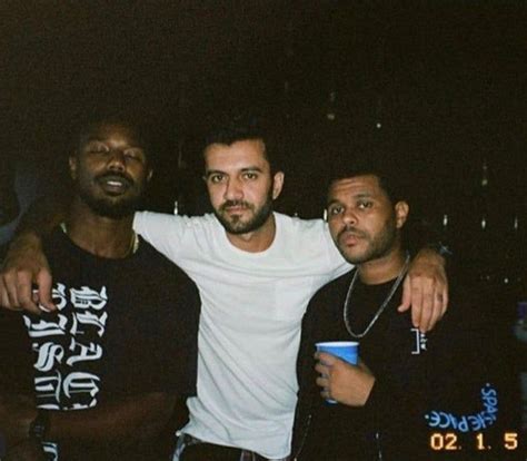 Three Men Standing Next To Each Other Posing For A Photo