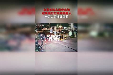 女司机驾车进停车场，结果误打方向冲向路人，一旁大哥被吓跳起