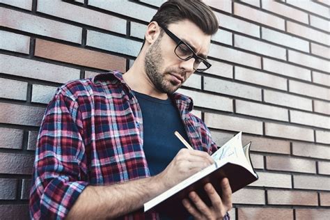 Chico Joven Inconformista Con Anteojos Leyendo Un Libro O Cuaderno