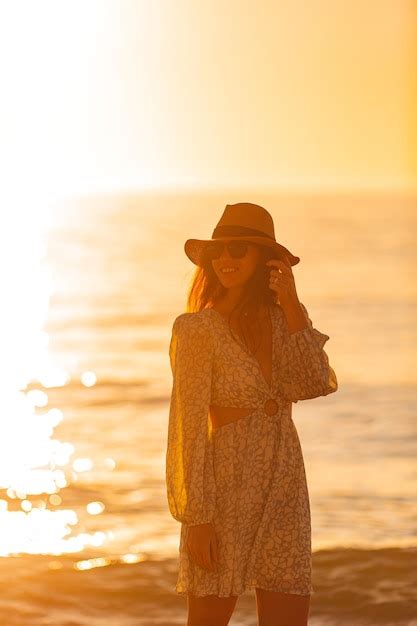 Premium Photo Young Beautiful Woman At Straw Hat On The Beach At Sunset