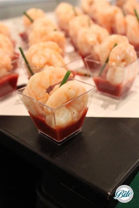 Small Plastic Bowls Filled With Shrimp On Top Of A Table