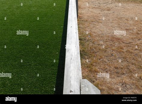 Artificial Grass On The Left And Dry Grass During Very Hot Weather