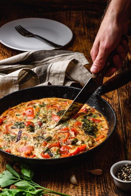 Premium Photo Hand With Knife Slices Vegetable Frittata With Broccoli