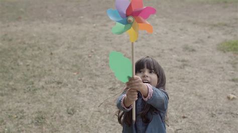 Vídeo Gratis Adorable chica latina jugando con abanico de papel en el