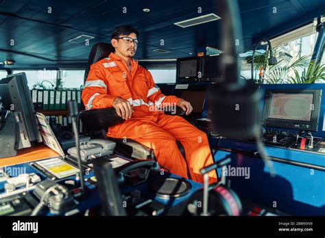 Filipino Deck Officer On Bridge Of Vessel Or Ship He Is Looking