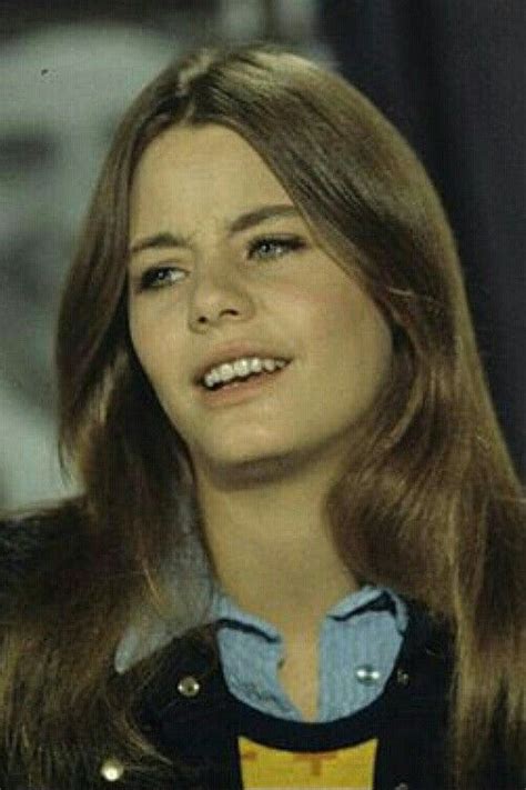 A Close Up Of A Person Wearing A Jacket And Smiling At The Camera With Long Hair