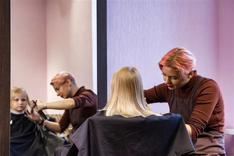 Friseurin macht Frisur für Baby im Friseursalon Friseurin macht