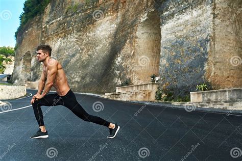 Fitness Man Stretching Body Exercising Before Running Outdoor Stock