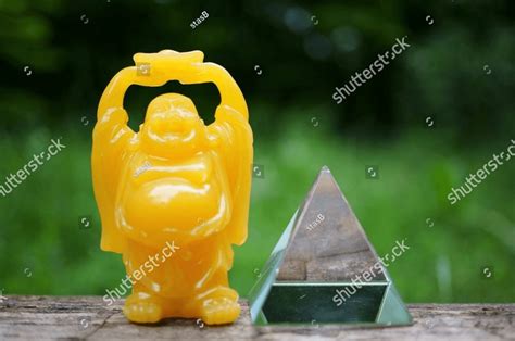 A Smiling Buddha Figurine And A Glass Pyramid Esotericism And Feng