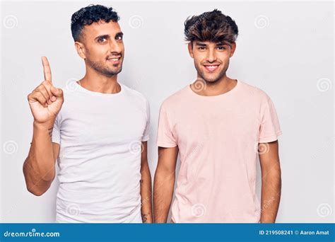Joven Pareja Gay Con Ropa Casual Mostrando Y Señalando Con El Dedo Número Uno Mientras Sonríe