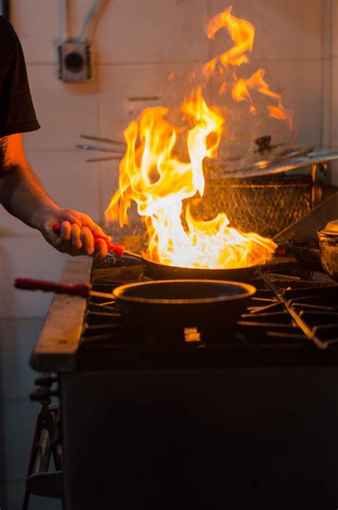 Imagen de Chef cocinando con fuego en la sartén FOTO GRATIS 100031173