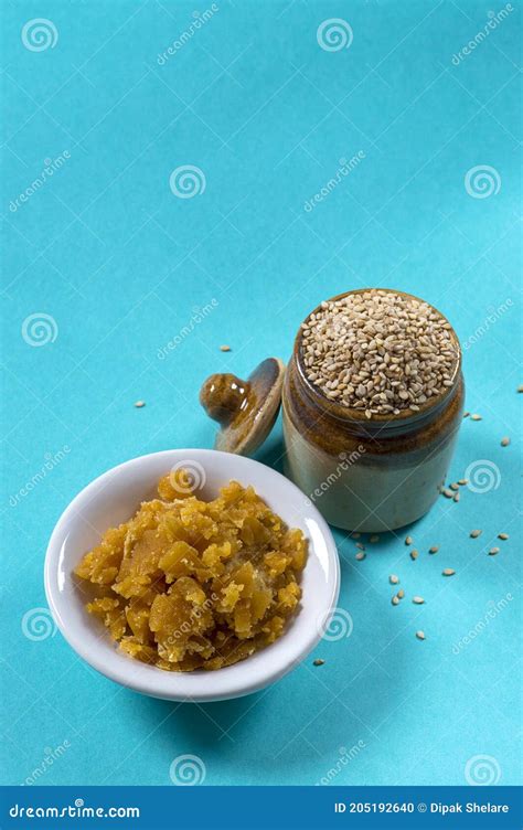 Sesame Seeds In Clay Pot With Jaggery In Bowl On Blue Background Stock