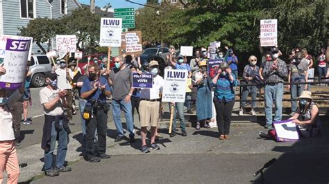 Dozens gather outside of Ballard post office for 'Save the Post Office' rally | KOMO