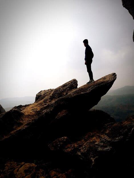 Premium Photo Silhouette Man Standing On Cliff Against Sky